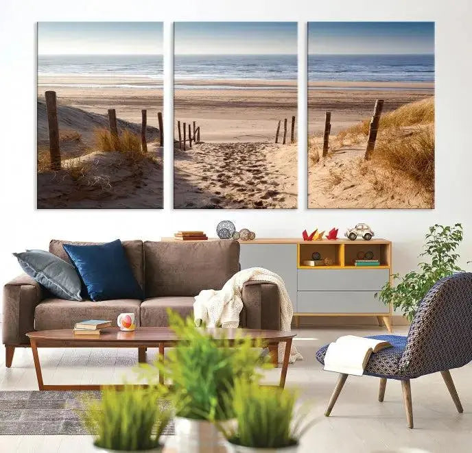 The "Serene Beach Path Canvas – Coastal Landscape Wall Art Triptych – Tranquil Ocean View for Living Room" is tastefully displayed, adding a beautiful coastal touch to the room's ambiance.