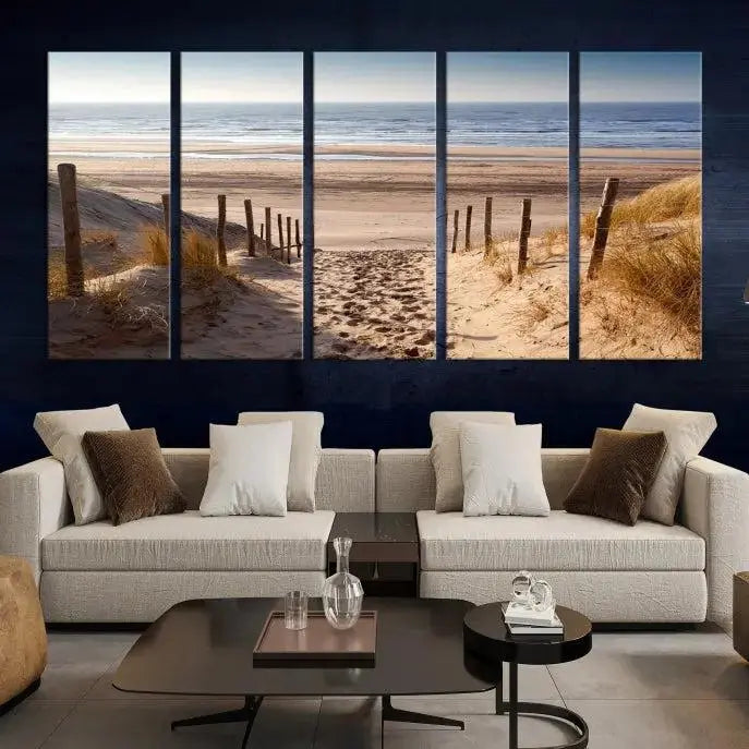 The "Serene Beach Path Canvas – Coastal Landscape Wall Art Triptych – Tranquil Ocean View for Living Room" is tastefully displayed, adding a beautiful coastal touch to the room's ambiance.