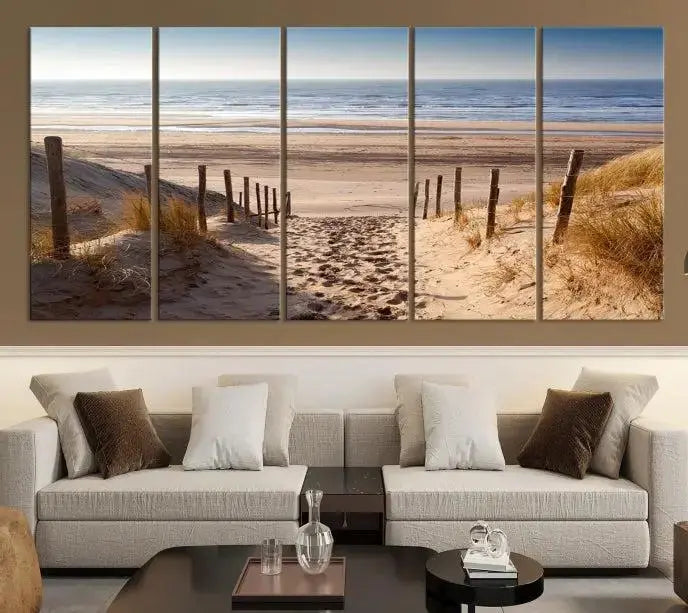 The "Serene Beach Path Canvas – Coastal Landscape Wall Art Triptych – Tranquil Ocean View for Living Room" is tastefully displayed, adding a beautiful coastal touch to the room's ambiance.