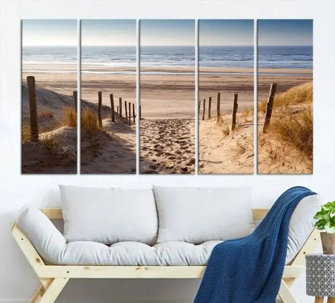 The "Serene Beach Path Canvas – Coastal Landscape Wall Art Triptych – Tranquil Ocean View for Living Room" is tastefully displayed, adding a beautiful coastal touch to the room's ambiance.