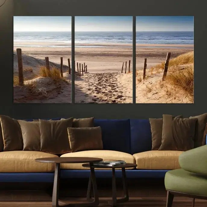 The "Serene Beach Path Canvas – Coastal Landscape Wall Art Triptych – Tranquil Ocean View for Living Room" is tastefully displayed, adding a beautiful coastal touch to the room's ambiance.