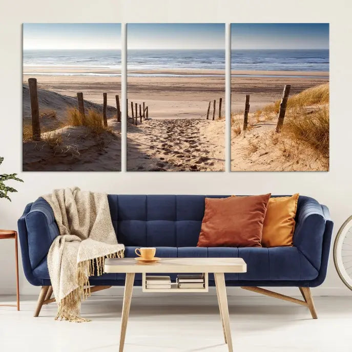 The "Serene Beach Path Canvas – Coastal Landscape Wall Art Triptych – Tranquil Ocean View for Living Room" is tastefully displayed, adding a beautiful coastal touch to the room's ambiance.