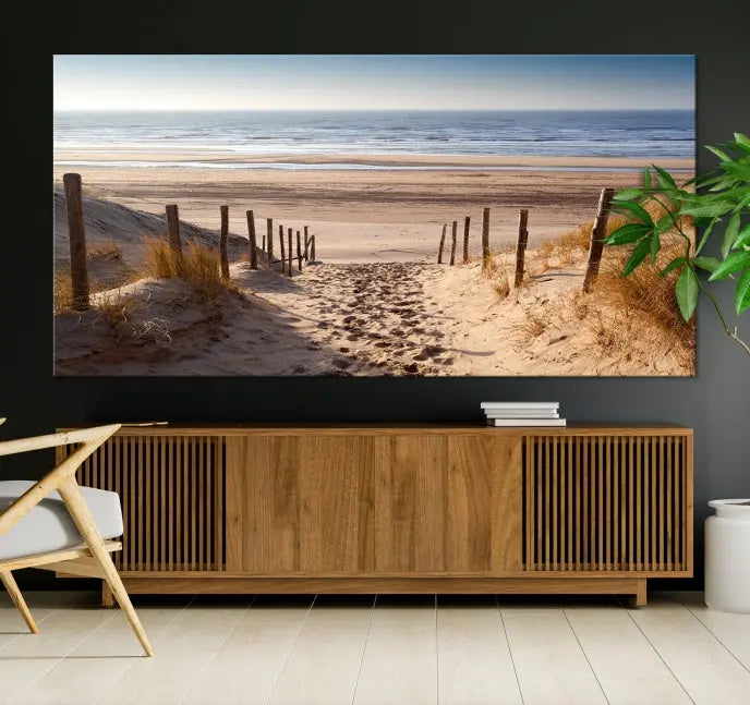 The "Serene Beach Path Canvas – Coastal Landscape Wall Art Triptych – Tranquil Ocean View for Living Room" is tastefully displayed, adding a beautiful coastal touch to the room's ambiance.