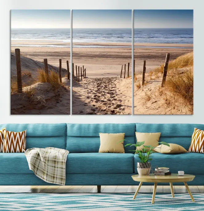 The "Serene Beach Path Canvas – Coastal Landscape Wall Art Triptych – Tranquil Ocean View for Living Room" is tastefully displayed, adding a beautiful coastal touch to the room's ambiance.