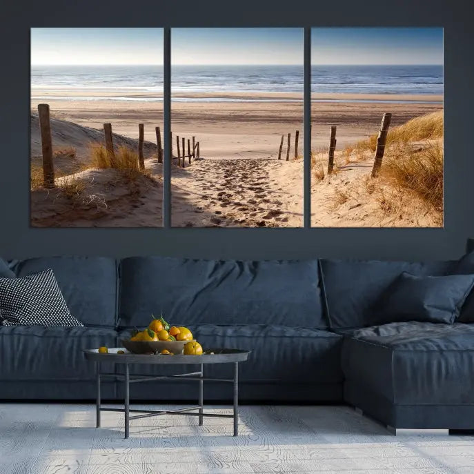 The "Serene Beach Path Canvas – Coastal Landscape Wall Art Triptych – Tranquil Ocean View for Living Room" is tastefully displayed, adding a beautiful coastal touch to the room's ambiance.