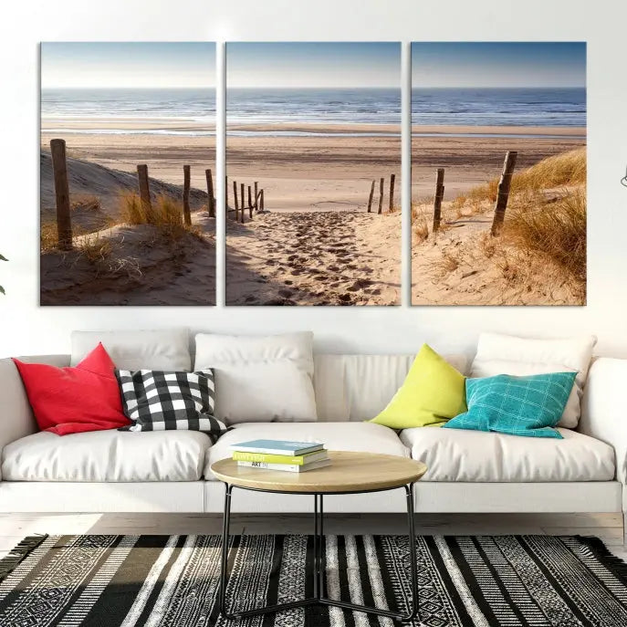 The "Serene Beach Path Canvas – Coastal Landscape Wall Art Triptych – Tranquil Ocean View for Living Room" is tastefully displayed, adding a beautiful coastal touch to the room's ambiance.