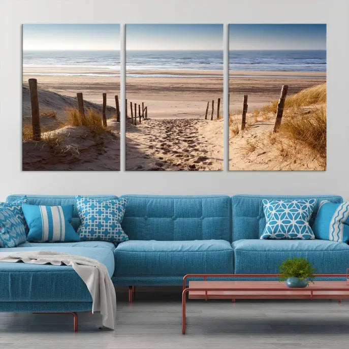 The "Serene Beach Path Canvas – Coastal Landscape Wall Art Triptych – Tranquil Ocean View for Living Room" is tastefully displayed, adding a beautiful coastal touch to the room's ambiance.