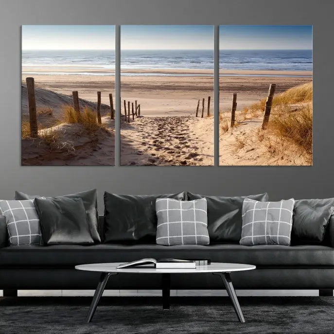 The "Serene Beach Path Canvas – Coastal Landscape Wall Art Triptych – Tranquil Ocean View for Living Room" is tastefully displayed, adding a beautiful coastal touch to the room's ambiance.