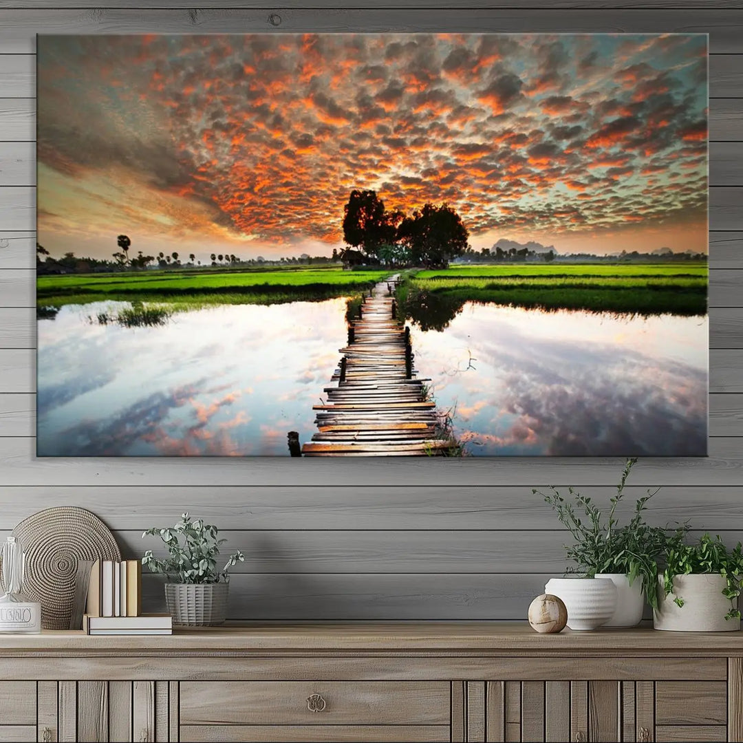 Serene sunset wooden bridge triptych canvas art. Giclee print with vibrant sunset reflections, perfect for tranquil and scenic spaces.