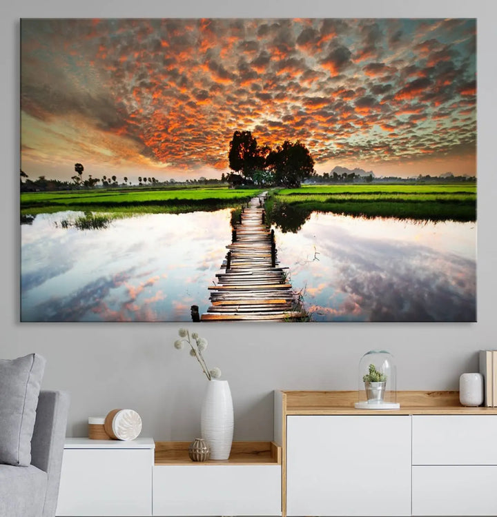 Serene sunset wooden bridge triptych canvas art. Giclee print with vibrant sunset reflections, perfect for tranquil and scenic spaces.