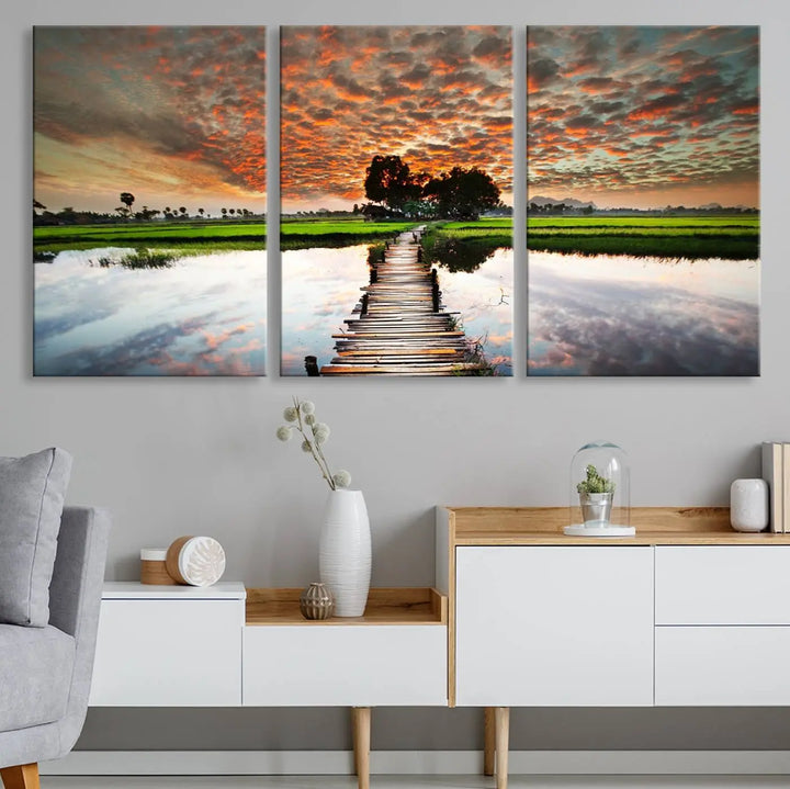 Serene sunset wooden bridge triptych canvas art. Giclee print with vibrant sunset reflections, perfect for tranquil and scenic spaces.