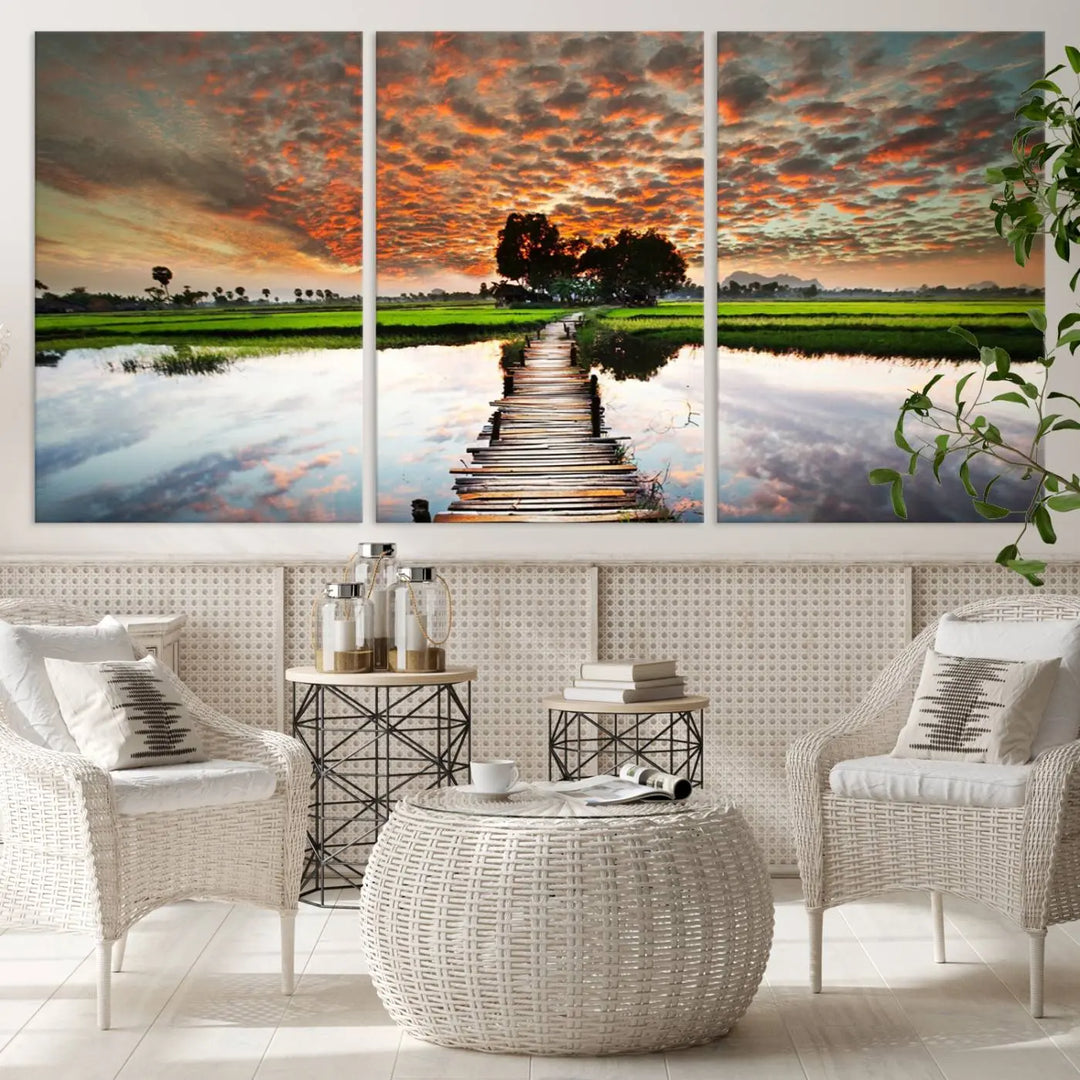 The "Serene Sunset Wooden Bridge Triptych Canvas Art" beautifully depicts a scenic landscape with reflections over water and a vibrant, cloudy sunset sky, making it an ideal choice for textured walls in tranquil spaces.