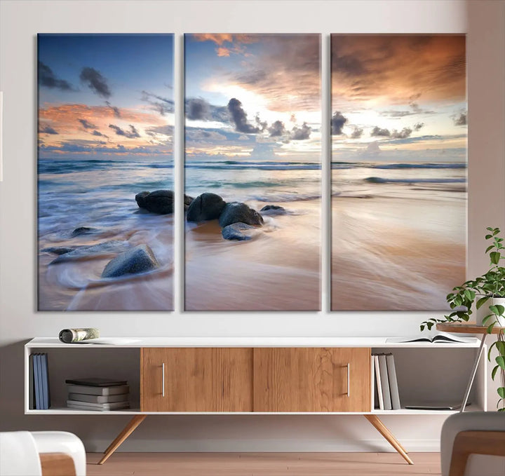 The "Serene Weather On The Beach Wall Art Canvas Print," featuring a tranquil beach scene with rocks and waves, is ready to hang and enjoy.