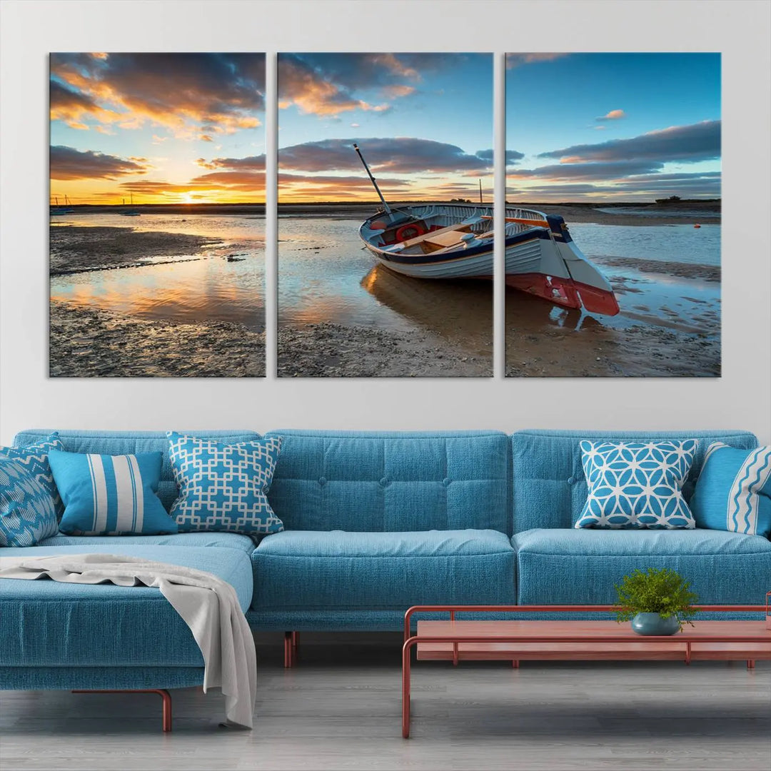 The "Small Boat At The Beach Sunset Wall Art Canvas Print," a three-panel masterpiece crafted on museum-quality canvas, hangs elegantly.