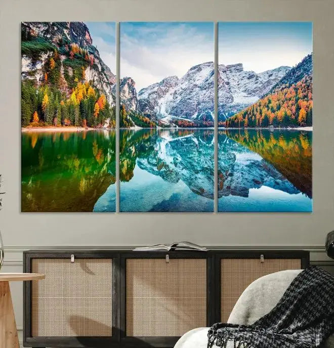 The "Spectacular Autumn View of Braies Lake Wall Art Canvas Print" showcases a serene mountain lake framed by colorful autumn trees reflected in the water. This museum-quality artwork is adorned with a UV-protective coating to maintain its vivid colors and elegantly gallery wrapped to enhance its contemporary appeal.