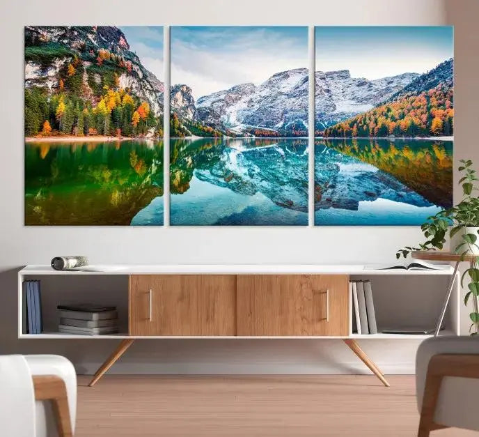 The "Spectacular Autumn View of Braies Lake Wall Art Canvas Print" showcases a serene mountain lake framed by colorful autumn trees reflected in the water. This museum-quality artwork is adorned with a UV-protective coating to maintain its vivid colors and elegantly gallery wrapped to enhance its contemporary appeal.