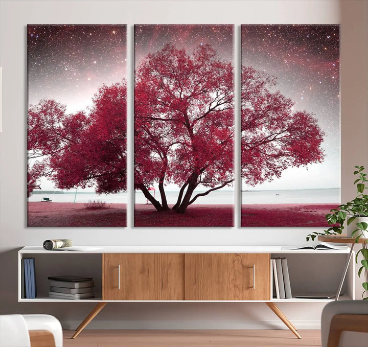 A living room adorned with a museum-quality triptych artwork on gallery-wrapped canvas titled "Spring Night Infrared Red Leaves and Tree," which showcases a pink tree against a starry sky.