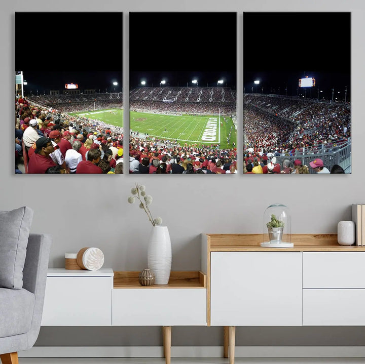 The living room features a large triptych wall art crafted on premium canvas, showcasing the "Stanford University Cardinal Football Team Print - Stanford Stadium," which depicts a crowded football stadium at night. Handmade in the USA.