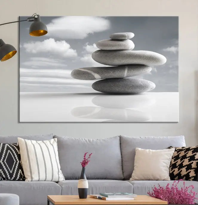 A gallery-quality Still Life Black and White Zen Stones Wall Art Canvas Print, featuring a triptych of stacked stones against a calm, cloudy background, adorns the room to bring an elegant touch.