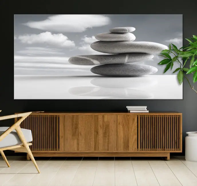 A gallery-quality Still Life Black and White Zen Stones Wall Art Canvas Print, featuring a triptych of stacked stones against a calm, cloudy background, adorns the room to bring an elegant touch.