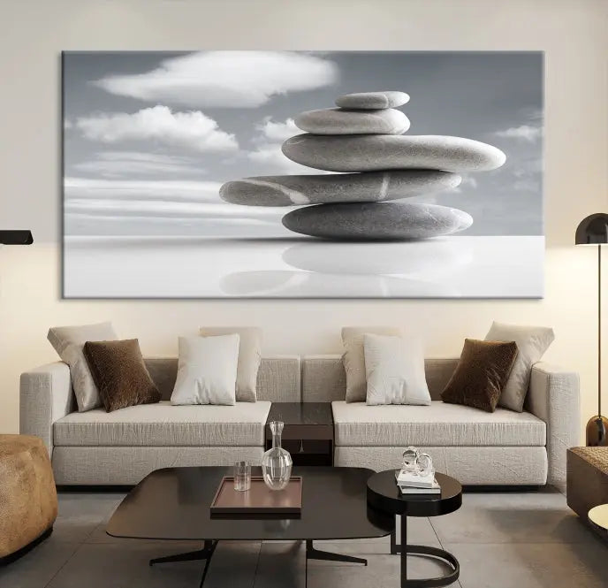 A gallery-quality Still Life Black and White Zen Stones Wall Art Canvas Print, featuring a triptych of stacked stones against a calm, cloudy background, adorns the room to bring an elegant touch.