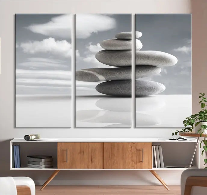 A gallery-quality Still Life Black and White Zen Stones Wall Art Canvas Print, featuring a triptych of stacked stones against a calm, cloudy background, adorns the room to bring an elegant touch.