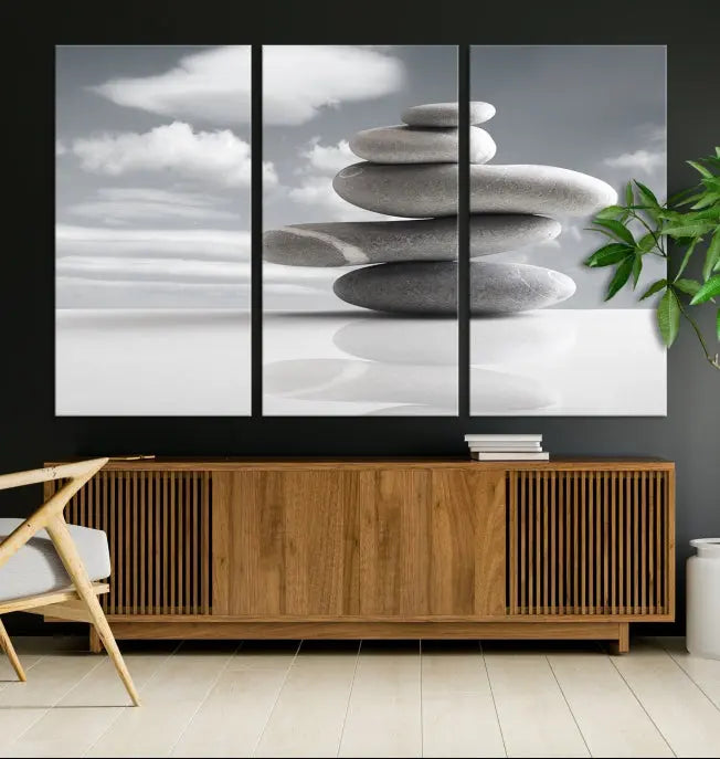 A gallery-quality Still Life Black and White Zen Stones Wall Art Canvas Print, featuring a triptych of stacked stones against a calm, cloudy background, adorns the room to bring an elegant touch.