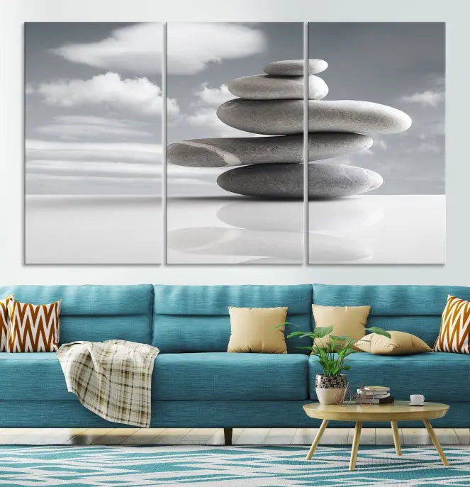 A gallery-quality Still Life Black and White Zen Stones Wall Art Canvas Print, featuring a triptych of stacked stones against a calm, cloudy background, adorns the room to bring an elegant touch.