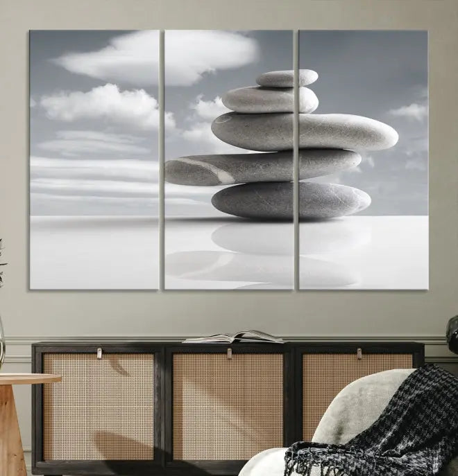 A gallery-quality Still Life Black and White Zen Stones Wall Art Canvas Print, featuring a triptych of stacked stones against a calm, cloudy background, adorns the room to bring an elegant touch.