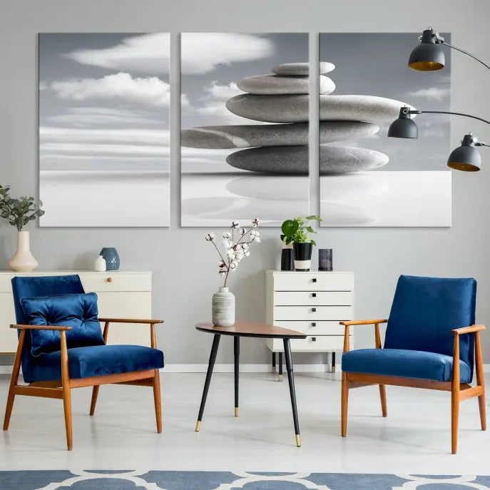 A gallery-quality Still Life Black and White Zen Stones Wall Art Canvas Print, featuring a triptych of stacked stones against a calm, cloudy background, adorns the room to bring an elegant touch.