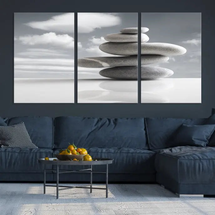 A gallery-quality Still Life Black and White Zen Stones Wall Art Canvas Print, featuring a triptych of stacked stones against a calm, cloudy background, adorns the room to bring an elegant touch.