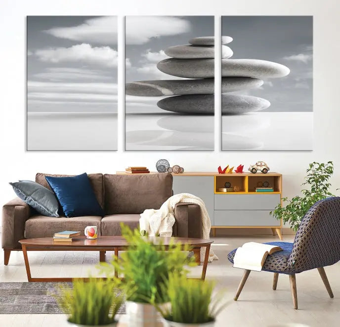 A gallery-quality Still Life Black and White Zen Stones Wall Art Canvas Print, featuring a triptych of stacked stones against a calm, cloudy background, adorns the room to bring an elegant touch.