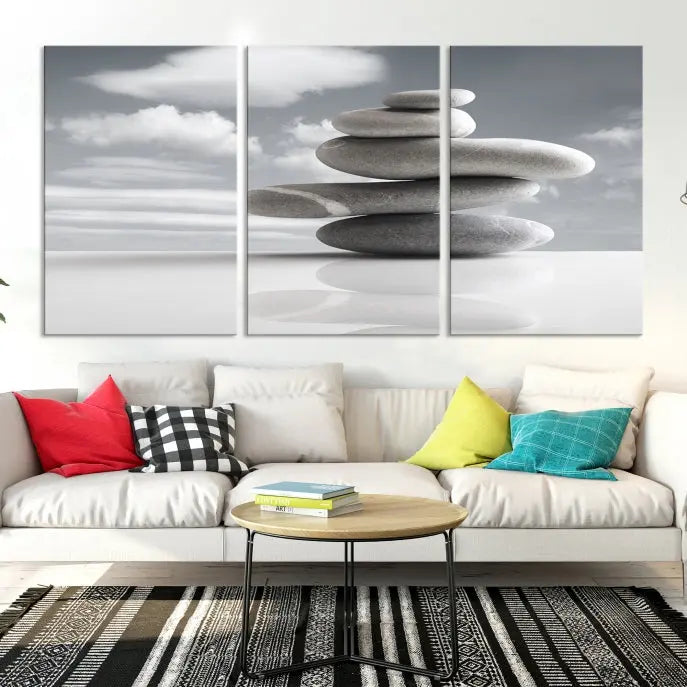 A gallery-quality Still Life Black and White Zen Stones Wall Art Canvas Print, featuring a triptych of stacked stones against a calm, cloudy background, adorns the room to bring an elegant touch.