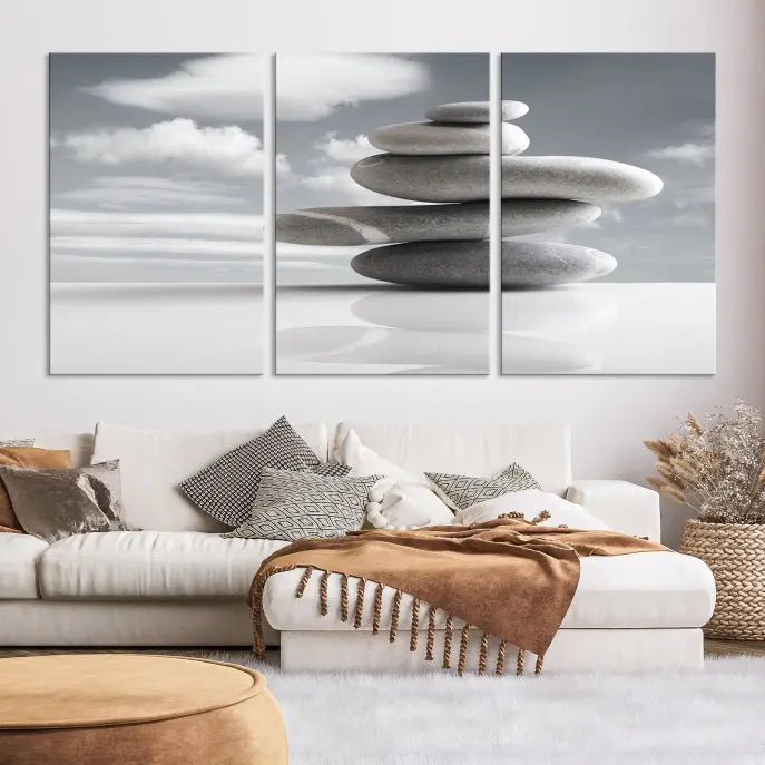 A gallery-quality Still Life Black and White Zen Stones Wall Art Canvas Print, featuring a triptych of stacked stones against a calm, cloudy background, adorns the room to bring an elegant touch.