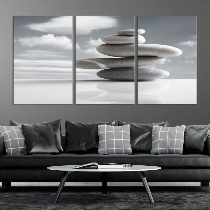 A gallery-quality Still Life Black and White Zen Stones Wall Art Canvas Print, featuring a triptych of stacked stones against a calm, cloudy background, adorns the room to bring an elegant touch.