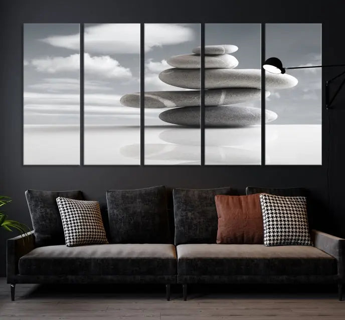 A gallery-quality Still Life Black and White Zen Stones Wall Art Canvas Print, featuring a triptych of stacked stones against a calm, cloudy background, adorns the room to bring an elegant touch.