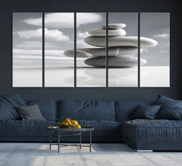 A gallery-quality Still Life Black and White Zen Stones Wall Art Canvas Print, featuring a triptych of stacked stones against a calm, cloudy background, adorns the room to bring an elegant touch.