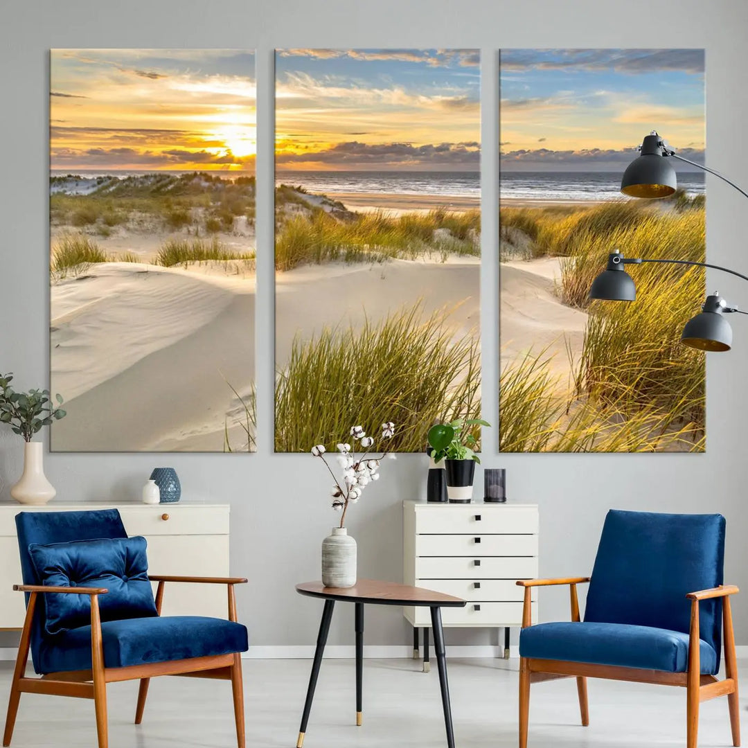 The "Sunrise on The Beach Wall Art Canvas Print" is a set of three museum-quality panels showcasing a beach sunrise with grassy dunes. Each piece includes a UV-protective coating and comes ready to hang for easy installation.