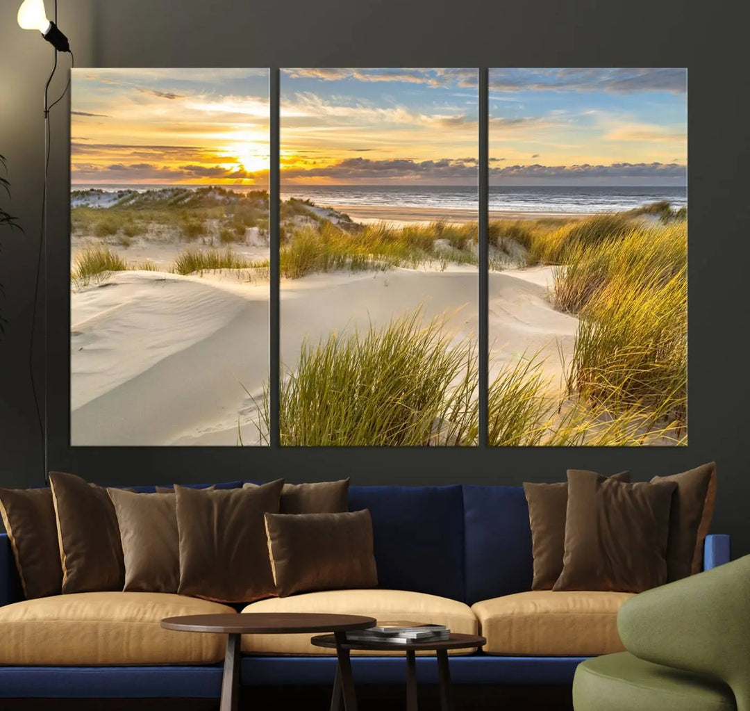 The "Sunrise on The Beach Wall Art Canvas Print" is a set of three museum-quality panels showcasing a beach sunrise with grassy dunes. Each piece includes a UV-protective coating and comes ready to hang for easy installation.