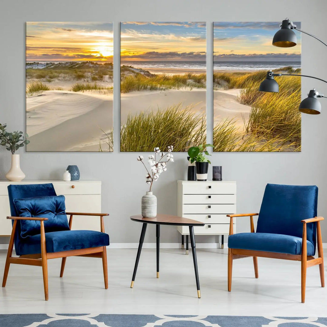 The "Sunrise on The Beach Wall Art Canvas Print" is a set of three museum-quality panels showcasing a beach sunrise with grassy dunes. Each piece includes a UV-protective coating and comes ready to hang for easy installation.