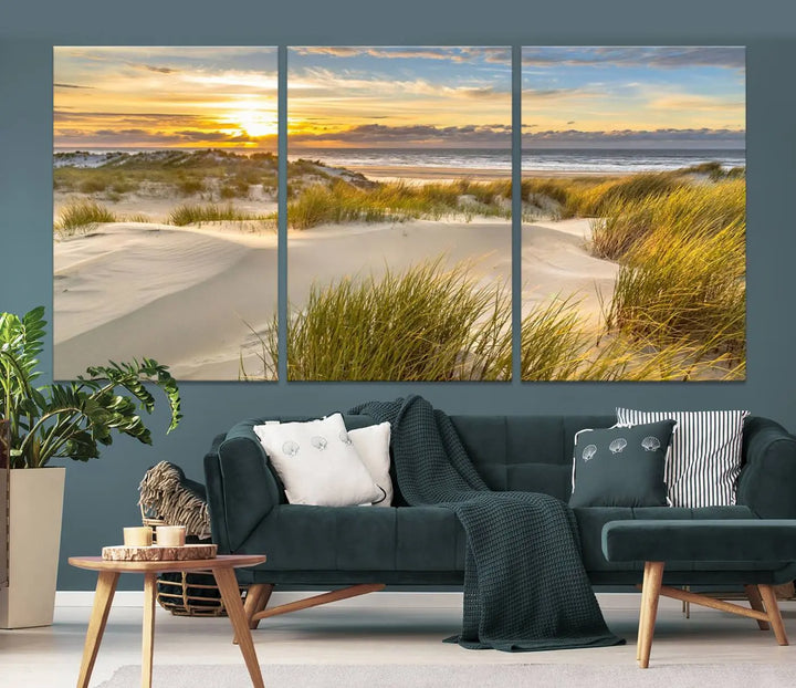 The "Sunrise on The Beach Wall Art Canvas Print" is a set of three museum-quality panels showcasing a beach sunrise with grassy dunes. Each piece includes a UV-protective coating and comes ready to hang for easy installation.