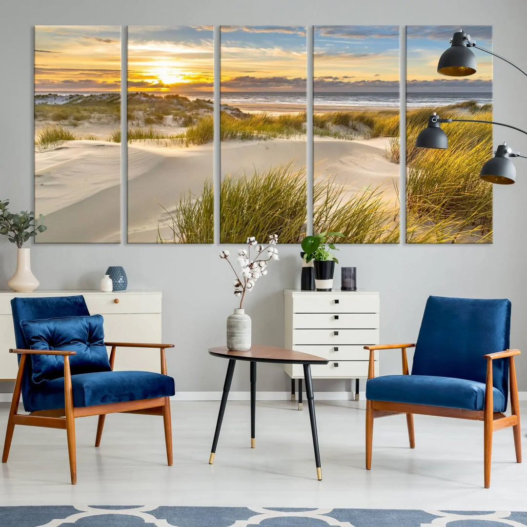 The "Sunrise on The Beach Wall Art Canvas Print" is a set of three museum-quality panels showcasing a beach sunrise with grassy dunes. Each piece includes a UV-protective coating and comes ready to hang for easy installation.