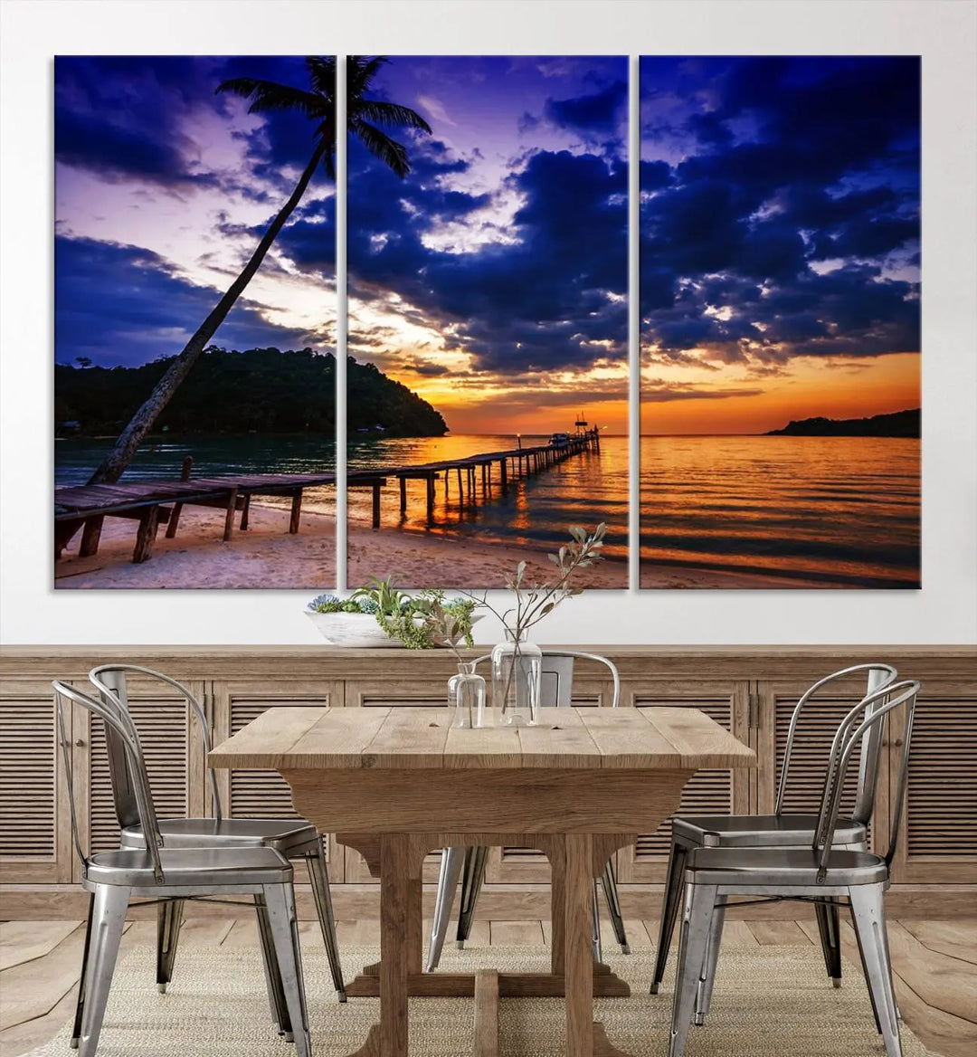 A stunning Sunset Beach Pier Wall Art, featuring a Tropical Island Sunset Canvas Print with palm trees and a pier seascape triptych, graces the wall, capturing the essence of coastal-inspired interiors.