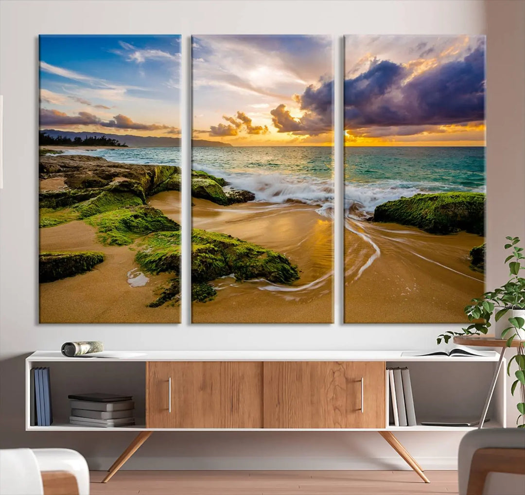 The Sunset Beach Wall Art Canvas Print is a gallery-wrapped triptych showcasing a beach scene with mossy rocks and a vibrant sunset. Made from museum-quality canvas and featuring a UV-protective coating, it elegantly provides both beauty and durability.