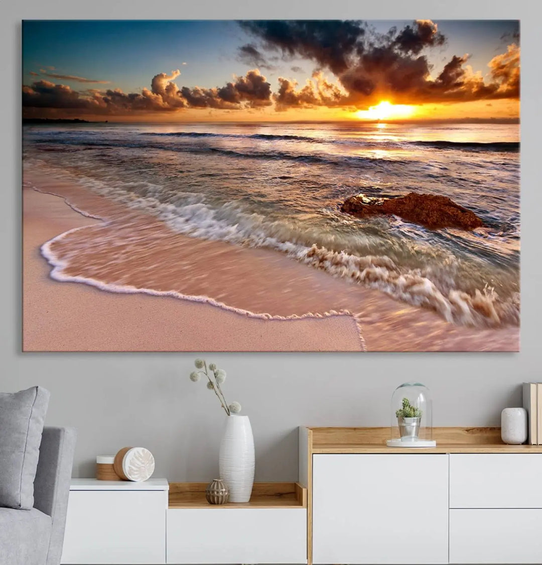 The Sunset Beach Waves Triptych Wall Art, featuring a tropical ocean scene on giclee canvas with a gallery wrap, adorns the wall in a cozy, coastal-themed living room.