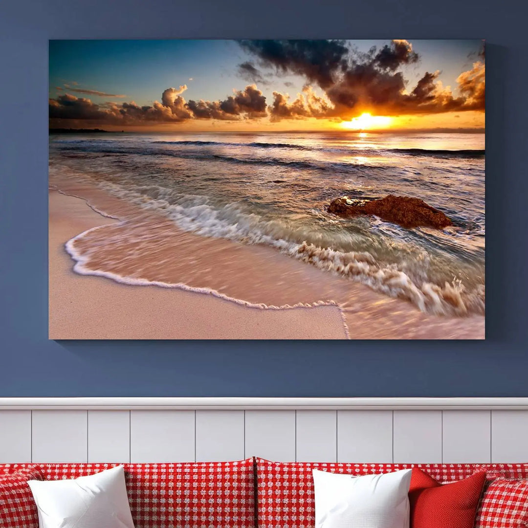 The Sunset Beach Waves Triptych Wall Art, featuring a tropical ocean scene on giclee canvas with a gallery wrap, adorns the wall in a cozy, coastal-themed living room.