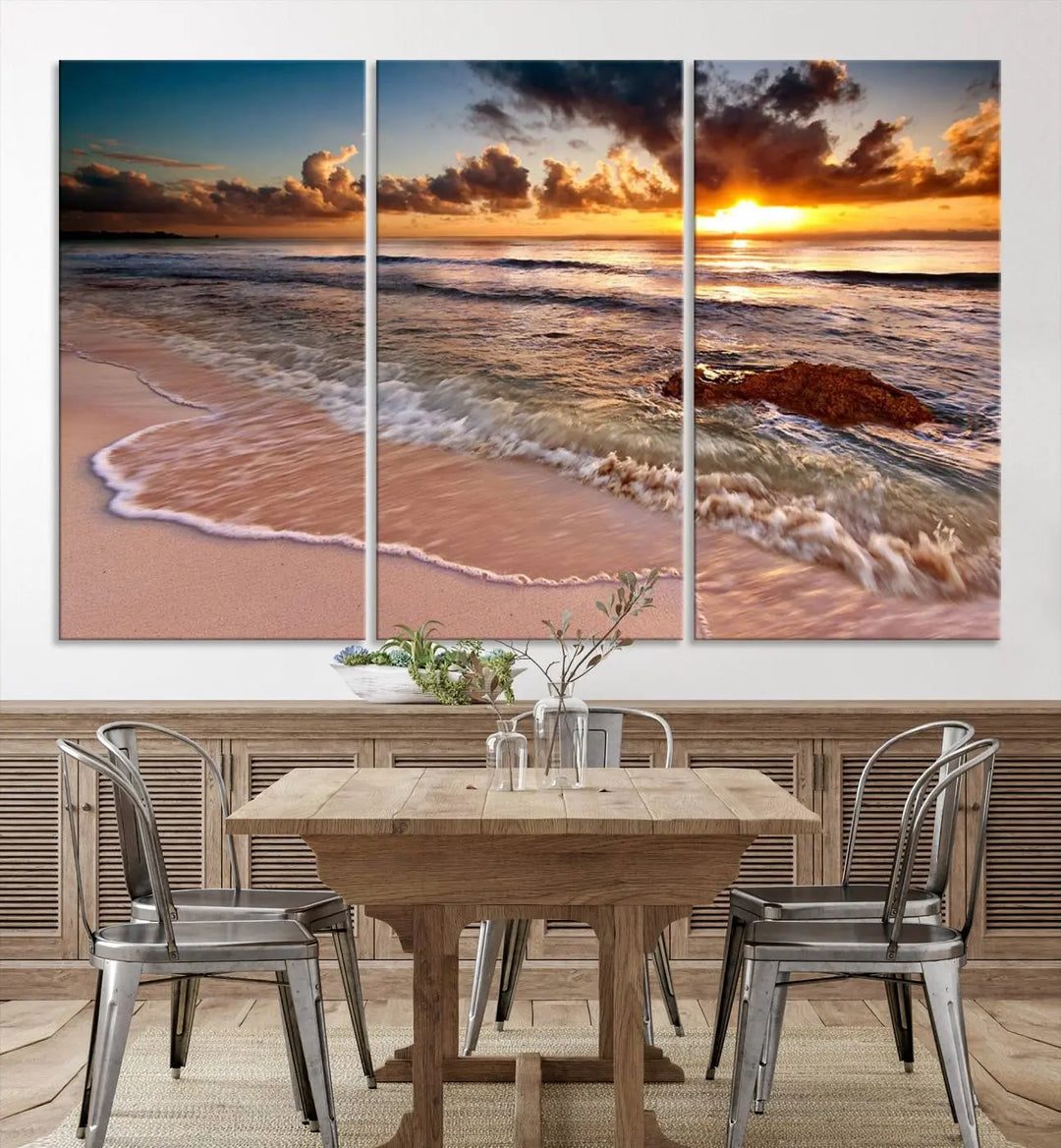 The Sunset Beach Waves Triptych Wall Art, featuring a tropical ocean scene on giclee canvas with a gallery wrap, adorns the wall in a cozy, coastal-themed living room.