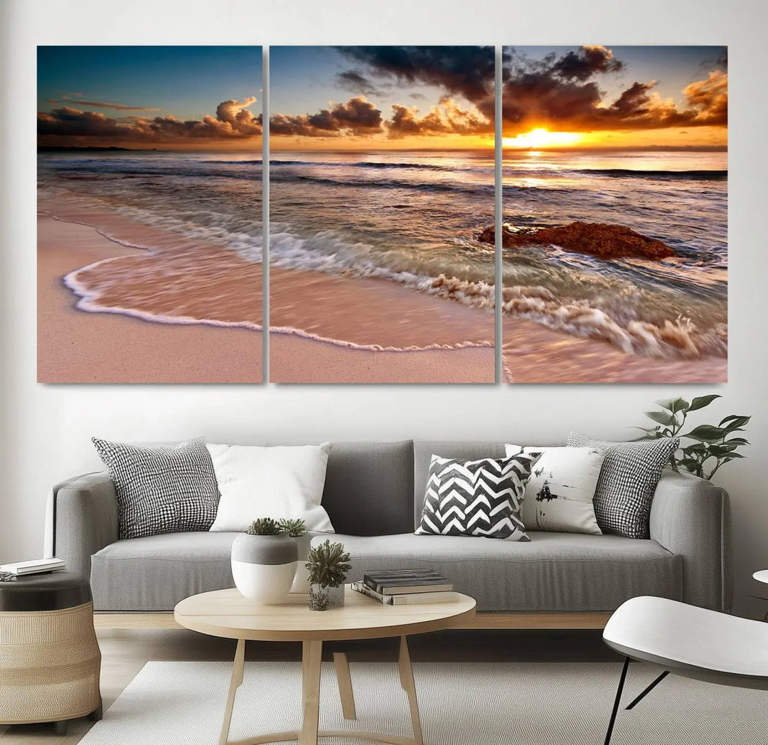 The Sunset Beach Waves Triptych Wall Art, featuring a tropical ocean scene on giclee canvas with a gallery wrap, adorns the wall in a cozy, coastal-themed living room.