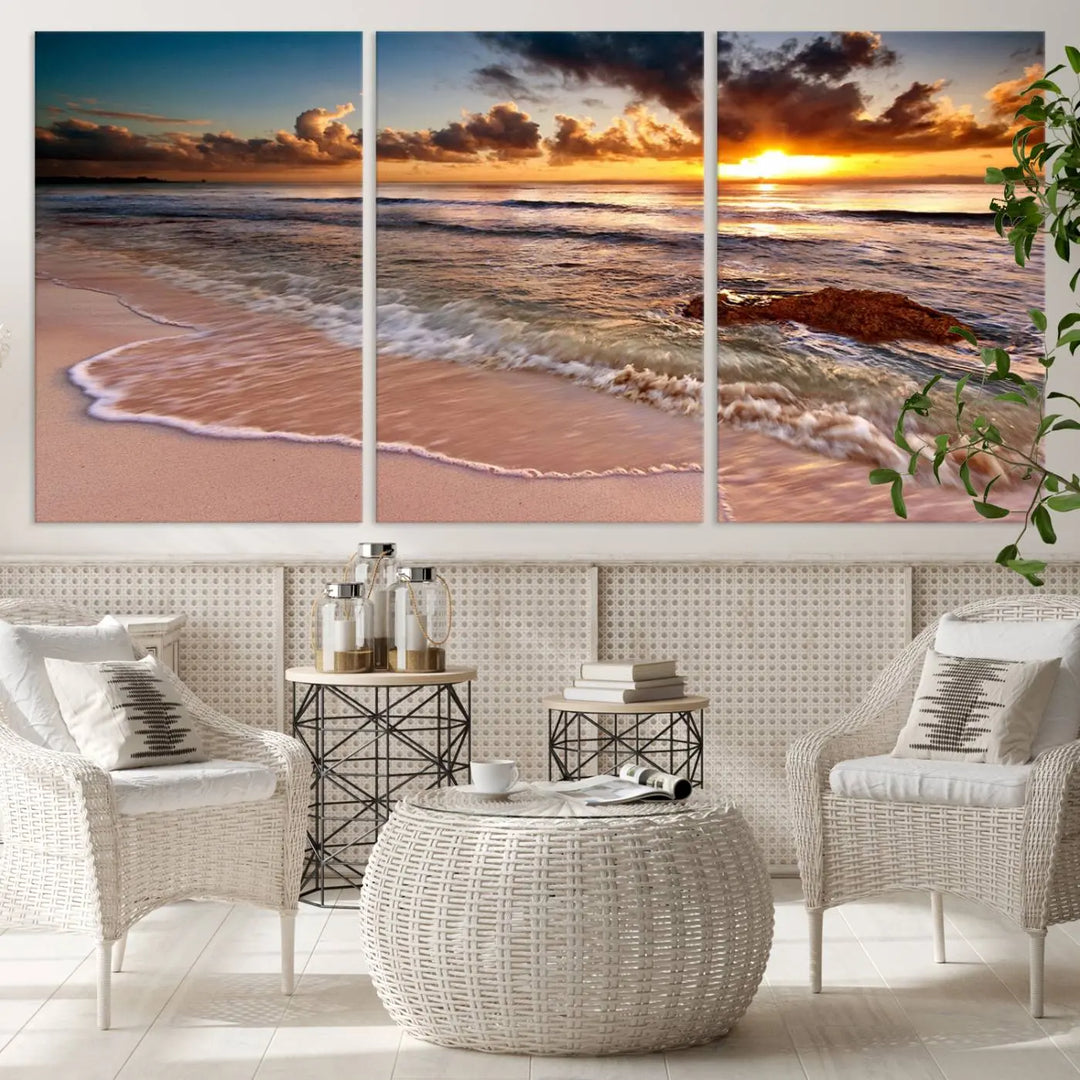 The Sunset Beach Waves Triptych Wall Art, featuring a tropical ocean scene on giclee canvas with a gallery wrap, adorns the wall in a cozy, coastal-themed living room.