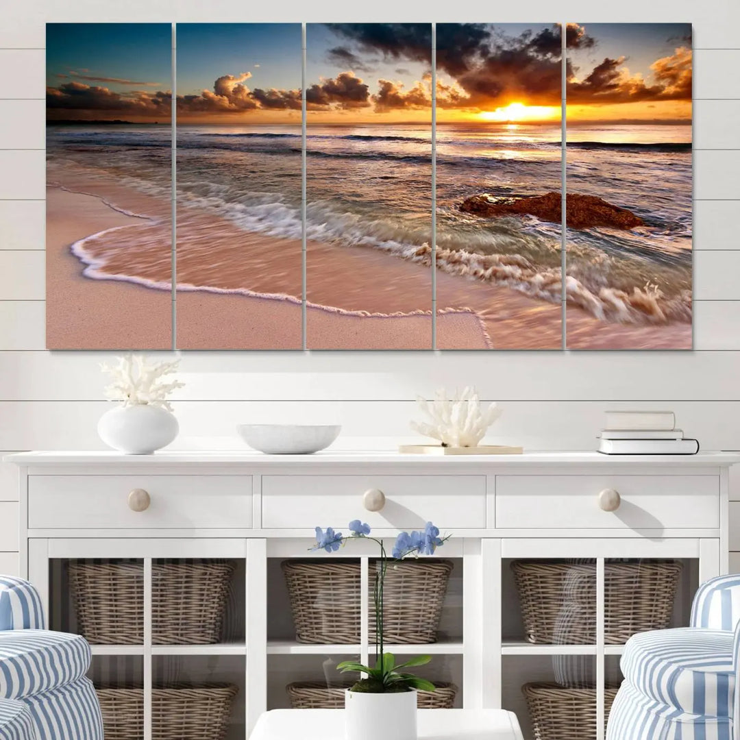 The Sunset Beach Waves Triptych Wall Art, featuring a tropical ocean scene on giclee canvas with a gallery wrap, adorns the wall in a cozy, coastal-themed living room.